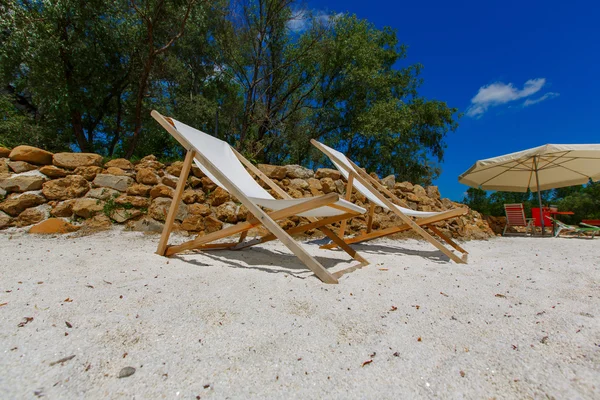 Deck chairs on white sand near the water — Stock Photo, Image