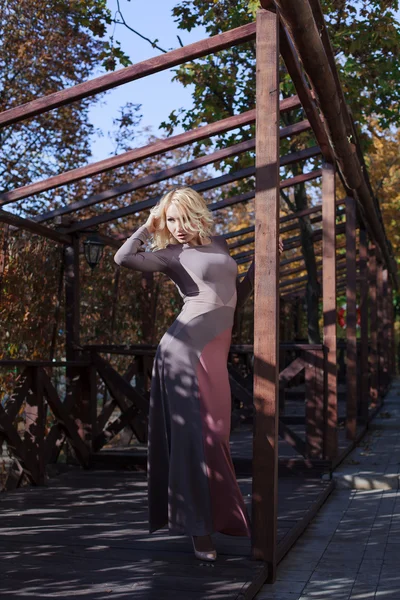 Красивая блондинка в платье прогулки осенью — стоковое фото
