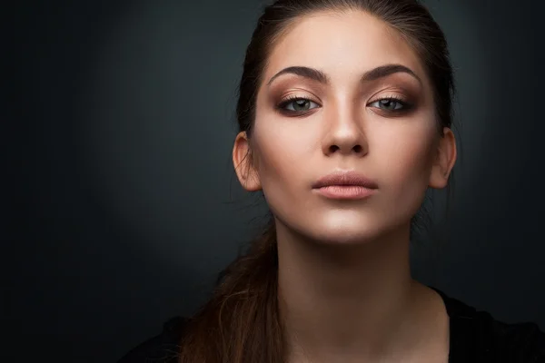 Portrait d'un beau jeune mannequin en gros plan sur fond sombre en studio — Photo