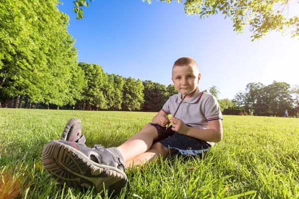 Счастливый мальчик, лежащий на траве — стоковое фото