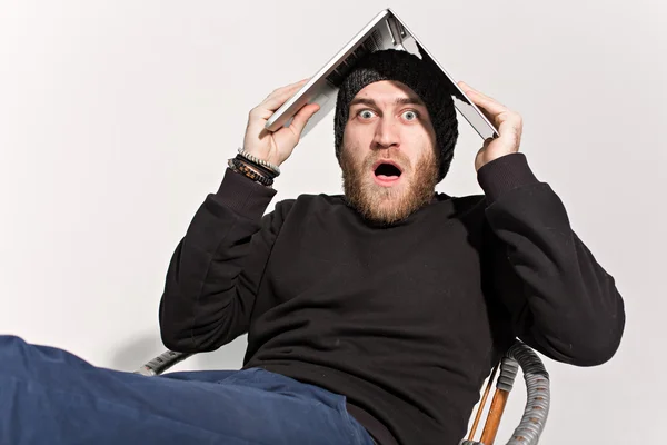 Young guy with a beard with a laptop — Stock Photo, Image