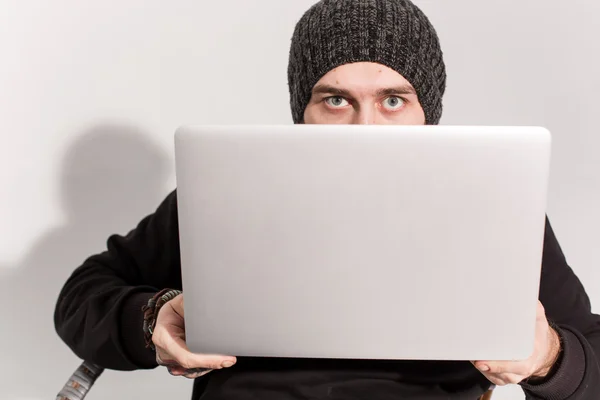 Young guy with a beard with a laptop — Stock Photo, Image