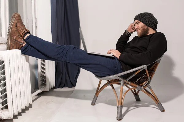 Young guy with a beard with a laptop — Stock Photo, Image