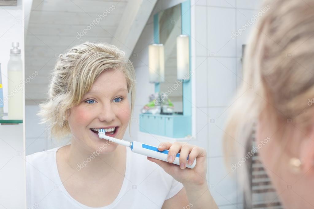 Woman holding toothbrush and brushing teeth