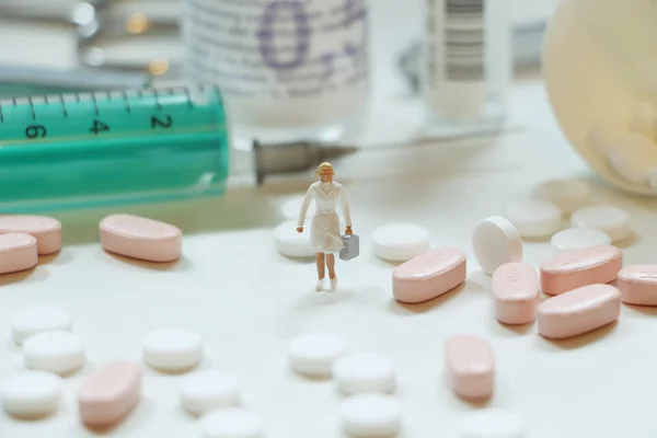Piller, medicin flaskor, medicinsk utrustning och en miniatyr — Stockfoto