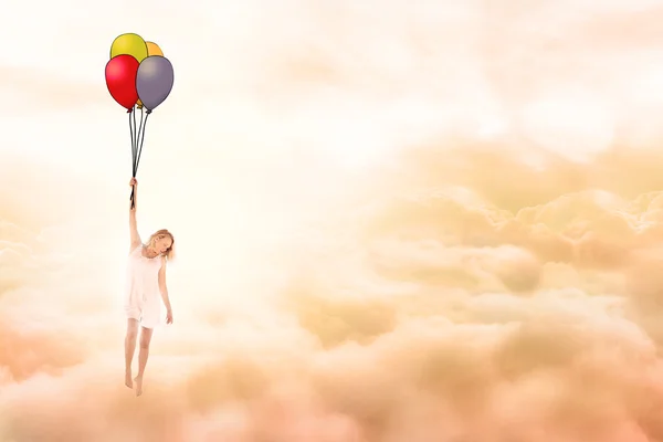 Junges Mädchen fliegt mit Luftballons in Wolken — Stockfoto