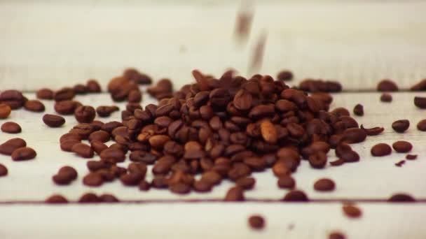 Grains de café tombant sur la table en bois — Video