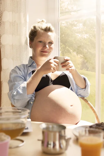 Mujer embarazada disfrutando de una taza de té — Foto de Stock