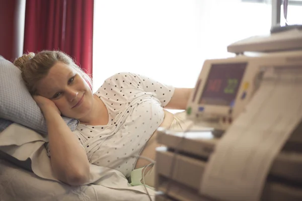 Вагітна жінка в лікарні і монітор серцебиття плоду — стокове фото