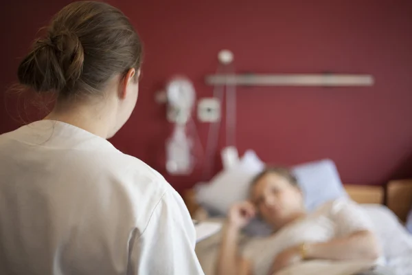 Wanita di rumah sakit berbicara dengan perawat, ruang fotokopi — Stok Foto