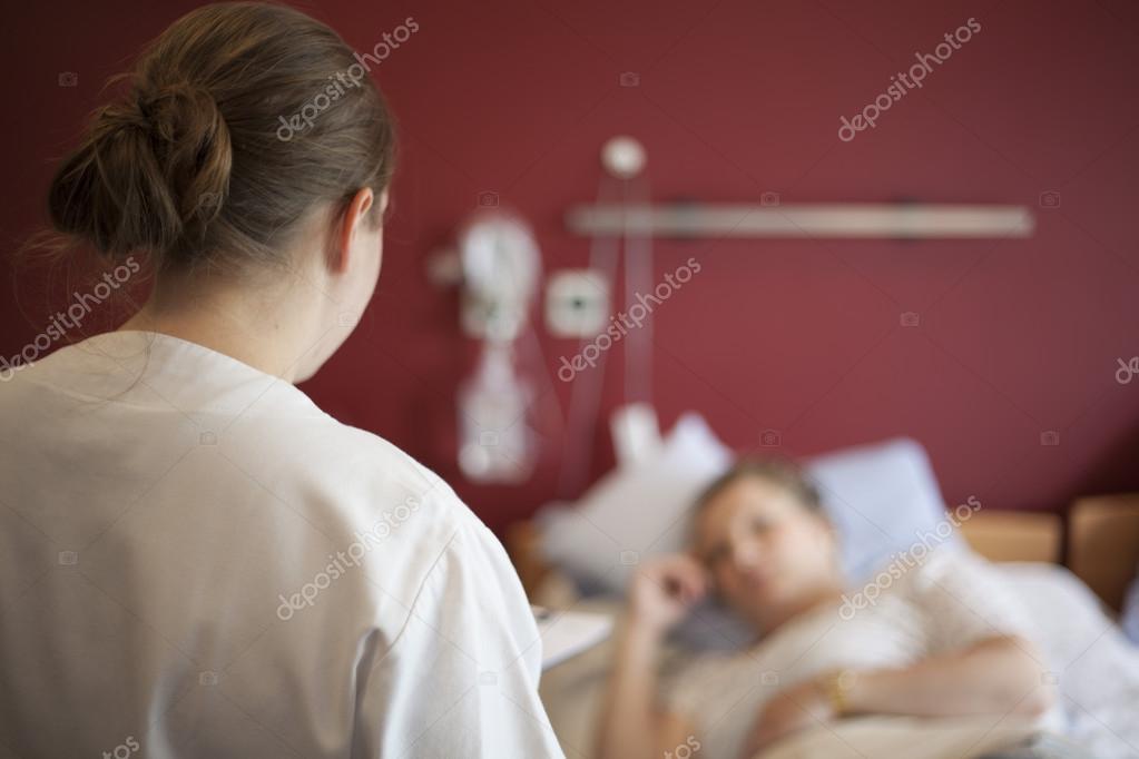 Woman in hospital talking to nurse, copy space