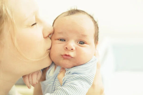 Mutter küsst ihr neugeborenes Kind — Stockfoto