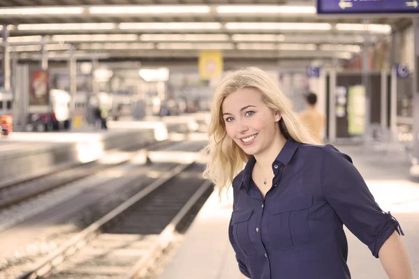 Young woman standing at platform waiting for the train Royalty Free Stock Images