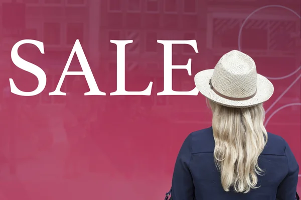 Woman in front of shop window with sale — Stock Photo, Image