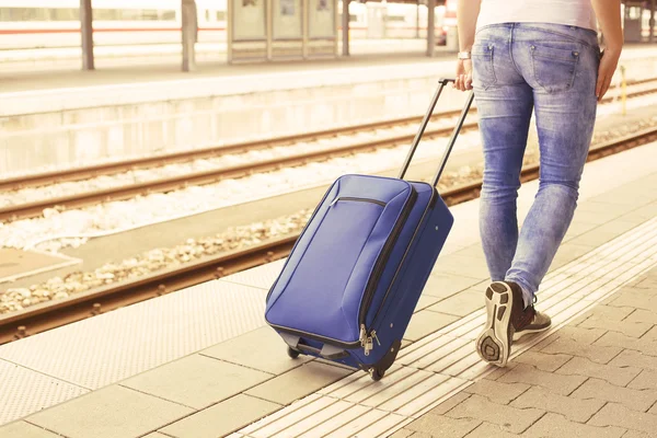 Womans legs with suitcase at the train station — Stock Photo, Image