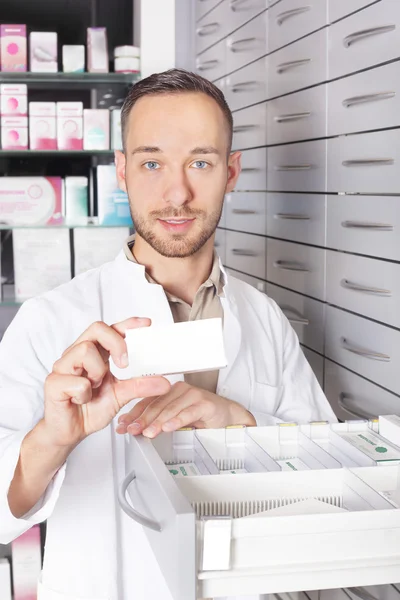 Young pharmacist at medicine cabinet