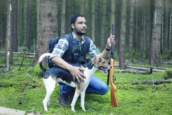 Interracial hunter in the forest with hunting dog — Stock Photo, Image