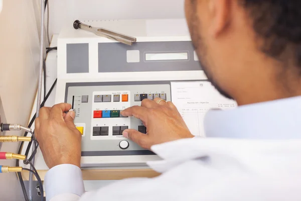 İşitme test makinesi üzerinde erkek otolaryngologist