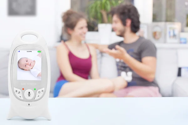 Couple enjoying free time not noticing that their baby isn't sleeping on baby monitor, copy space — Stock Photo, Image