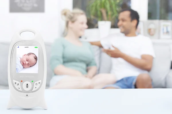 Interracial couple enjoying free time while baby is sleeping on baby monitor, copy space — Stock Photo, Image