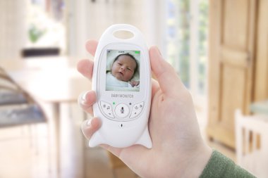 Mother checking he newborn through baby monitor clipart
