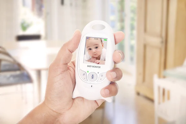 Father checking baby through baby monitor — Stock Photo, Image