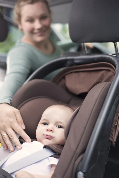 Mother checking on baby while in the car — Stock Photo, Image