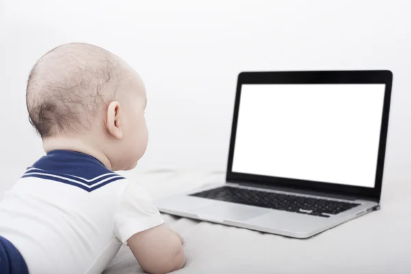 Säugling legt sich hin und schaut auf Computer mit Copyspace — Stockfoto