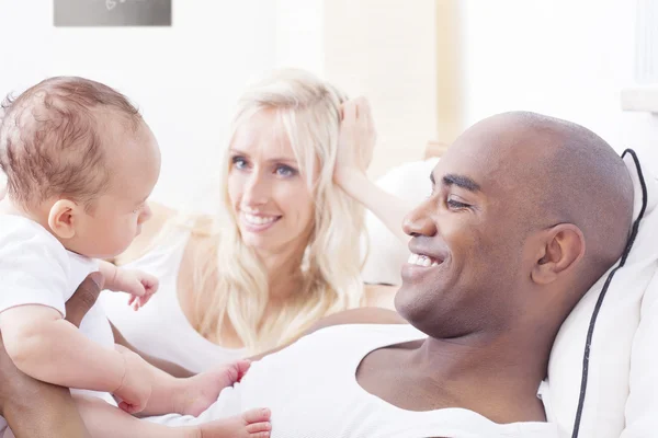 Счастливая межрасовая семья, мать, отец и ребенок — стоковое фото
