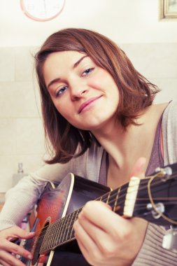 Güzel esmer kadın bir gitar müzik bestelemek