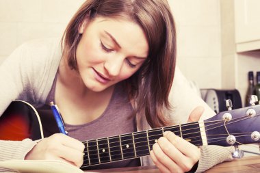 Güzel esmer kadın bir gitar müzik bestelemek