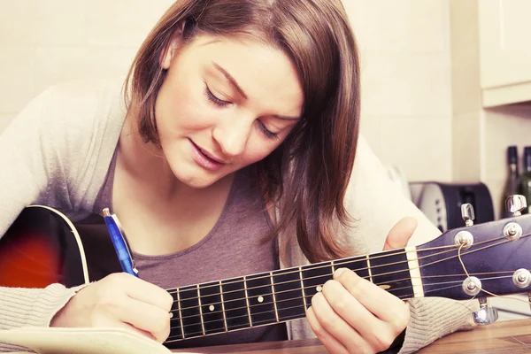 Hermosa mujer morena componiendo música en una guitarra —  Fotos de Stock