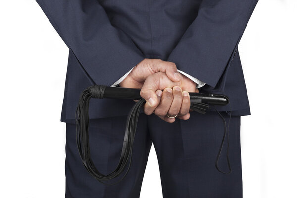 Leather whip held by dominant master in a suit
