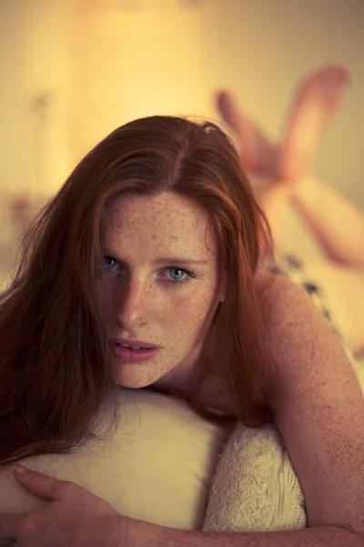 Freckled redhead in a bedroom at Sunset — Stock Photo, Image