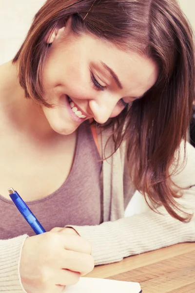 Mujer joven escribe a diario negro — Foto de Stock