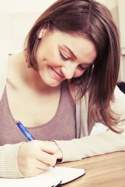 Mujer joven escribe a diario negro Imagen de archivo