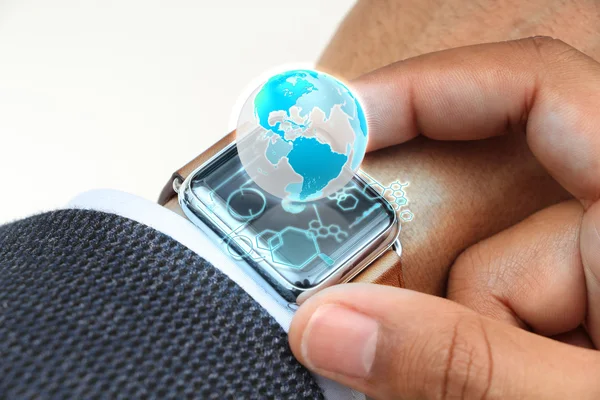 Close up of hand with globe hologram on smartwatch — Stock Photo, Image