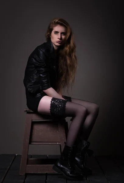 Siyah elbise ve deri ceket çekici kadın oturuyor