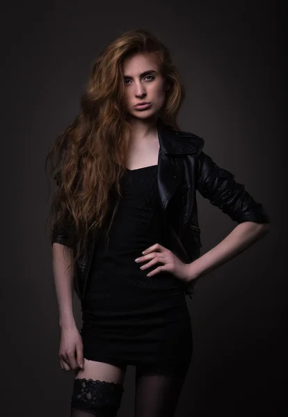 Mujer atractiva en vestido negro y chaqueta de cuero — Foto de Stock