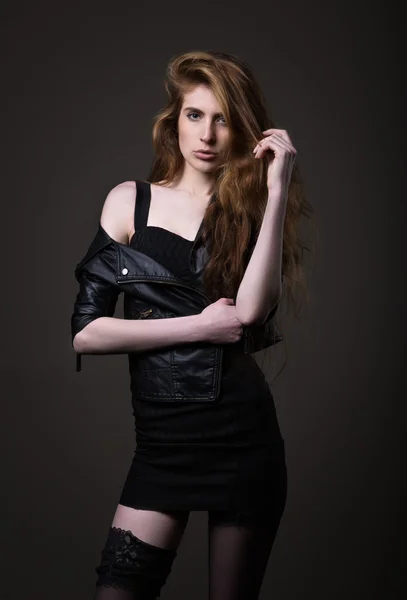 Woman in black dress, leather jacket and stockings. — Stock Photo, Image
