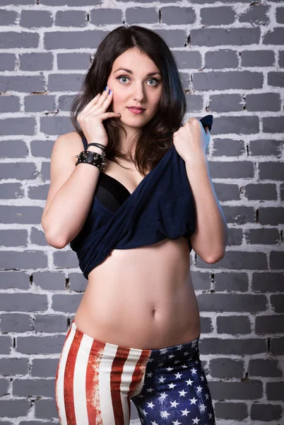 Beautiful girl in dark blue shirt in black bra in American flag — Stock Photo, Image