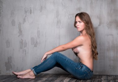 Ahşap katta oturan Jeans üstsüz kız