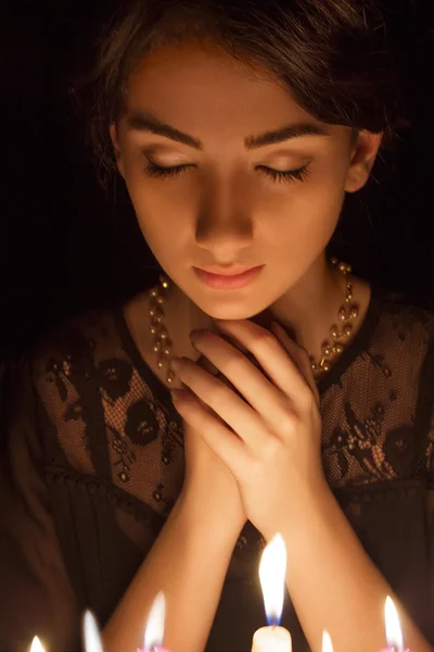 Modlí žena se svíčkami — Stock fotografie