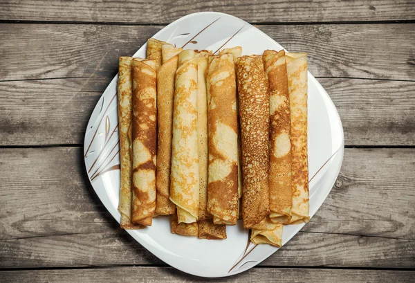 Rostad rullade pannkakor på en fyrkantig tallrik. — Stockfoto