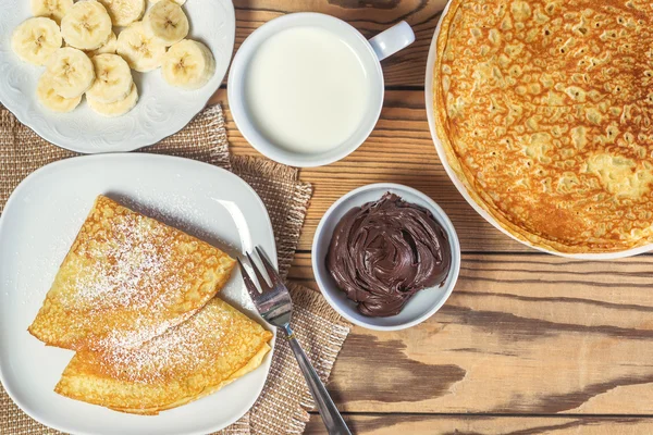 Pfannkuchen mit einer Banane und einer Tasse Milch — Stockfoto