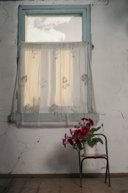 Görünüm penceresi, bir sandalye ve retro çiçekler ile eski odası