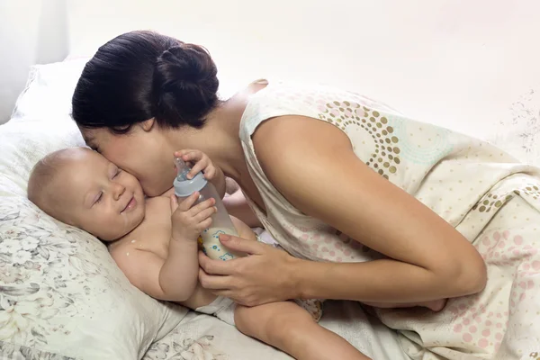 Mamma che abbraccia un bambino gioioso. Dopo aver mangiato. A casa. . — Foto Stock