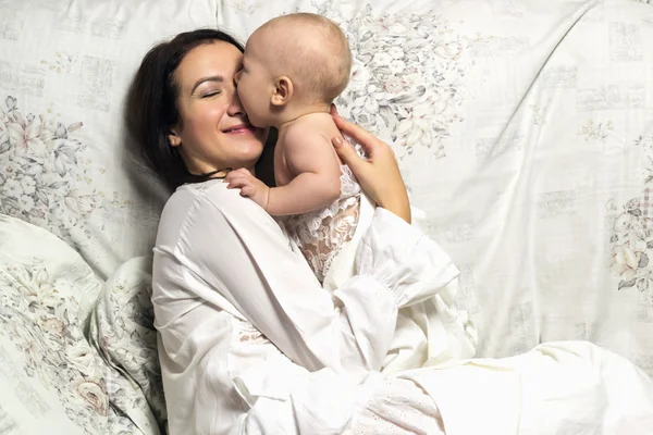 Madre tiernamente abraza a su hijo — Foto de Stock