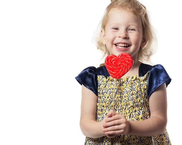 Girl child holding a heart-shaped lollipop . Isolated . — Stock Photo, Image