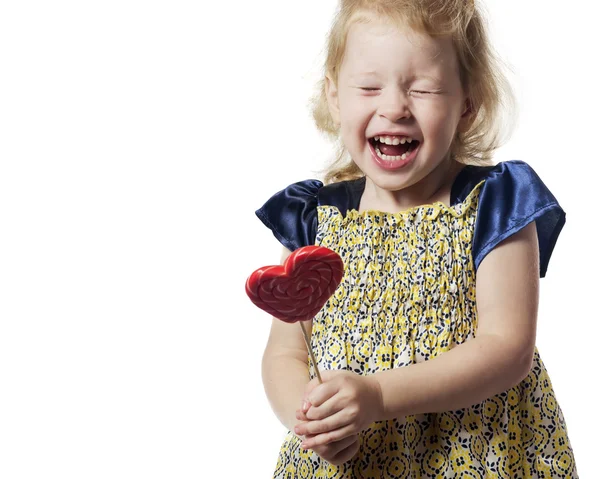 Kalp şeklinde bir lolipop tutan kız çocuk. Izole . — Stok fotoğraf